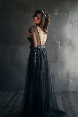 Fashion model in long black dress with crown