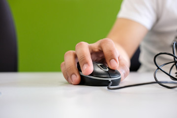 Fototapeta premium Man holding computer mouse in his hand, on the table