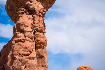 Rock climber on top of a hoodoo, Utah