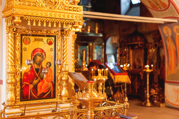 Golden candleholder and icons, traditional interior of Orthodox church. Russia.