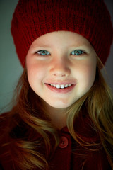 Baby 3 years old with blue eyes and white teeth in a red beret.Hair long