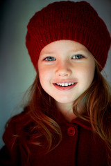 Baby 3 years old with blue eyes and white teeth in a red beret.Hair long