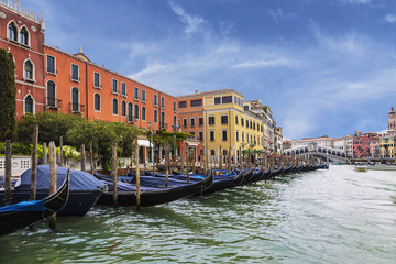 Fototapeta na wymiar View of the Grand canal, a pier with gondolas and Rialto bridge on the horizon, Venice, Italy