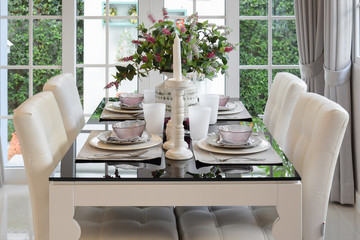 dining table and comfortable chairs in vintage style with elegant table setting