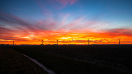 Windmills for electric power production at sunset