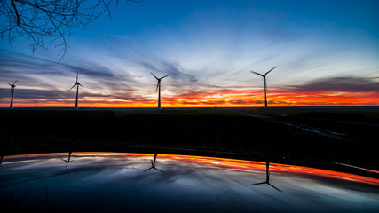 Fototapeta na wymiar Windmills for electric power production at sunset