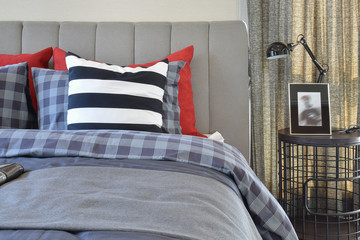 modern bedroom interior with striped pillow on bed and bedside table lamp at home