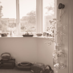 Vase of gypsophila hanging on door knob