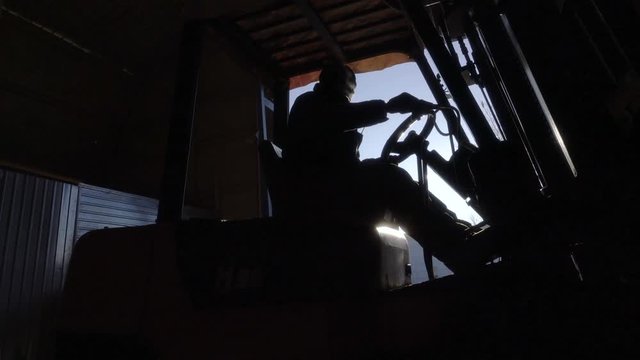 Diesel Forklift Truck lowers the huge part. Working in the warehouse in winter