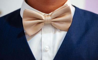 Gold bow tie on grooms neck
