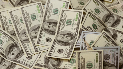 One hundred dollars pile as background.