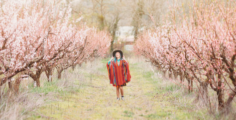 Boho style woman walking in spring garden.