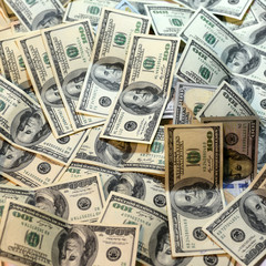 One hundred dollars pile as background.