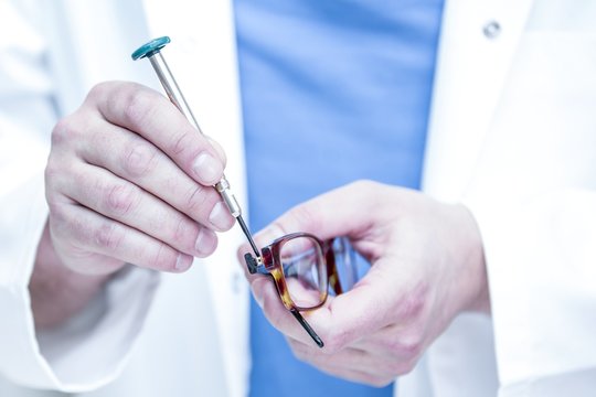 Optician repairing eyeglasses