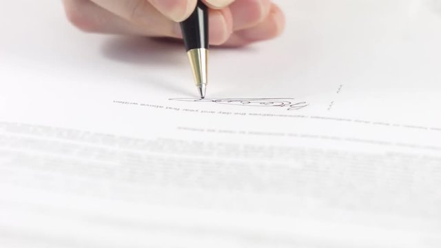 The man signing with ballpen some financial  or business papers (contract, agreement, NDA, documents, application, insurance, form, report, mortgage, certificate)