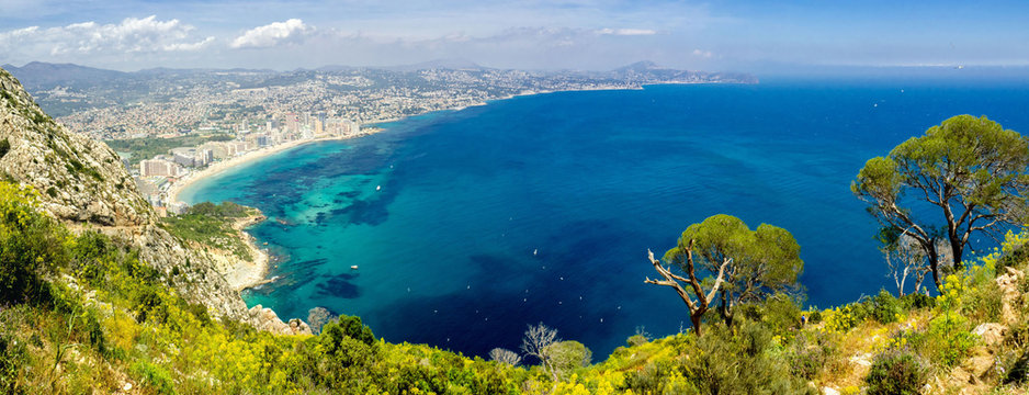 Panoramic landscape of Calpe. Ascension and hiking in the Rock of Ifach. Vacation and sunshine tourism on the beaches of Alicante, Spain. 