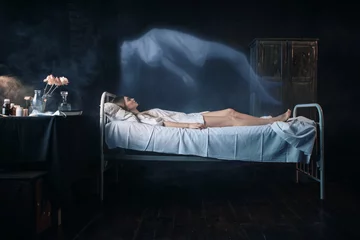 Rolgordijnen Ill woman lying in hospital bed, soul leaves body © Nomad_Soul