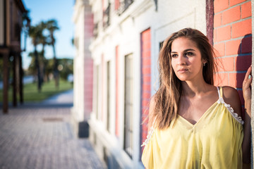 young pretty woman smiling isolated close up outdoor with a yellow dress