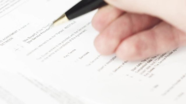 Reviewing documents with pen (NDA, agreement, contract)