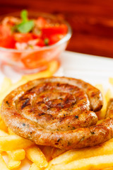 Fire grilled sausage with fries and tomato salad
