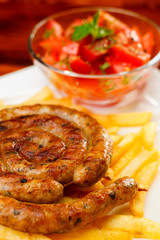 Fire grilled sausage with fries and tomato salad