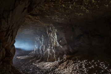 A ray of light in the cave - obrazy, fototapety, plakaty