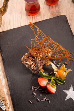 Brauni. Two layers juicy chocolate the braun impregnated with dense caramel and covered with pecan nuts