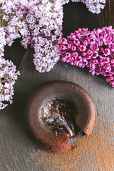 Classic chocolate fondant on a dark background with flowers
