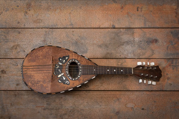 Old grunge mandolin on wooden wall