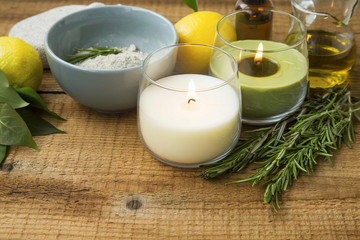 Fototapeta na wymiar Spa still life with candles, salt, rosemary herb, olive oil on wooden background, aromatherapy and skincare setting