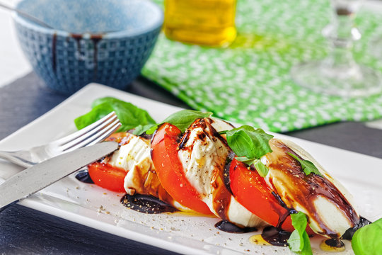 Tomate-Mozzarella in Scheiben geschnitten und seviert auf einem Teller