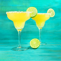 Lemon Margarita cocktails on vibrant turquoise with copyspace