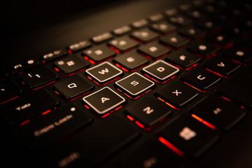 Black Laptop Computer Keyboard With Different WASD Buttons, and Illuminated Red Backlight