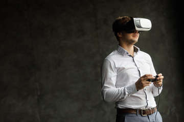 The VR headset design is generic and no logos, Man wearing virtual reality goggles watching movies or playing video games, dark photo