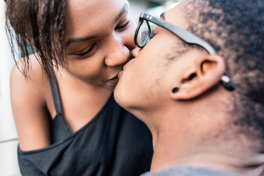Close-up of African American young couple kissing outdoors in summer