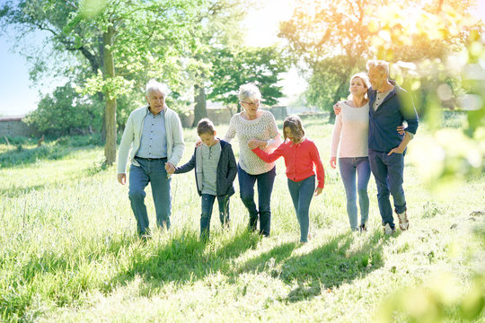 Happy Family Of 6 Walking In Park