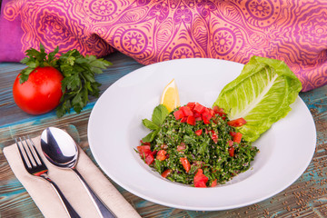 Traditional salad of their small cut parsley with fresh tomatoes, onions and stewed grains of wheat, in lemon juice, mint and olive oil sauce