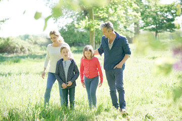 Cheerful family walking in park on sunny week-end