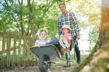 Daddy riding kids in wheelbarrow