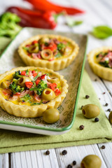Salty tartlets with bacon, bell pepper, broccoli, cheese, onion, egg and olives