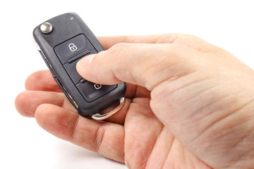 Man's hand presses button on the ignition key