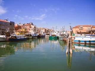 Fototapeta na wymiar Fishing boats moored in a canal in Chioggia, Italy.