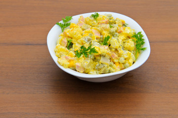 Russian traditional salad olivier on wooden table