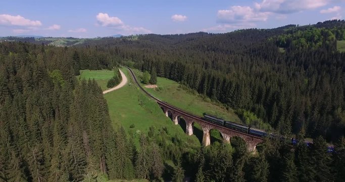 the train goes the old bridge in the Carpathian Mountains