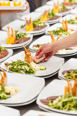 Cook is garnishing appetizer plates