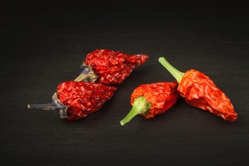 Spice advertising. Dried chili on a black wooden table. Sale of spices. Cultivation of peppers.