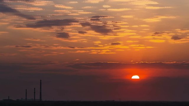 Time Lapse of Industrial pollution and smog sunrise with sun rays and dark clouds.