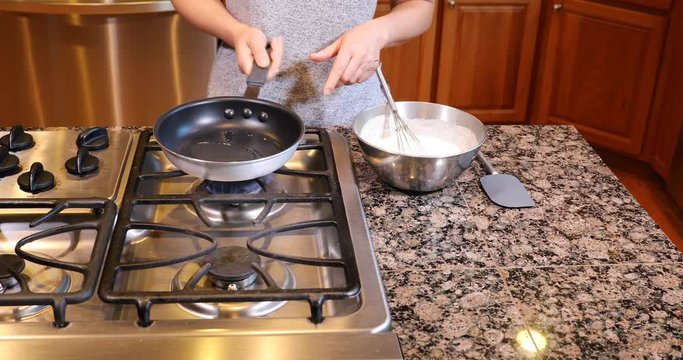 Preparing the frying pan with hot oil to cook the pancake batter