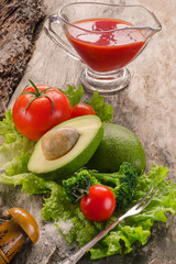 Avocado, tomatoes, lettuce, broccoli on wooden board.