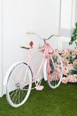 Fototapeta na wymiar White Bicycle near beautiful Flowers on vintage background in spring season